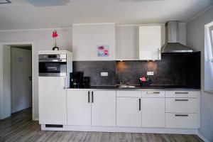 a kitchen with white cabinets and a sink at Ferienpark Winterberg in Winterberg