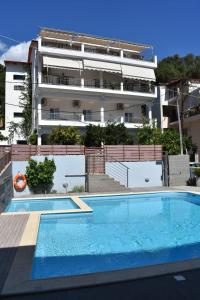 a building with a swimming pool in front of a building at Christina Studios & Apartments in Parga