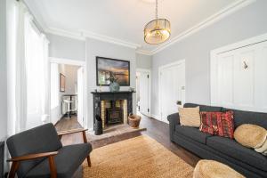 a living room with a couch and a fireplace at The Gate Lodge in Broughty Ferry