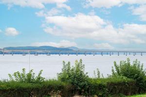 una gran masa de agua con un puente en el fondo en The Gate Lodge, en Broughty Ferry