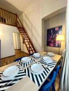 uma sala de jantar com uma mesa com cadeiras e uma escada em Casa Marsili - Luxury Apartment em Turim