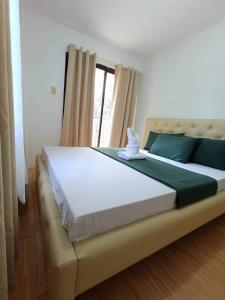 Cette chambre comprend un grand lit et une fenêtre. dans l'établissement Davao 2br One Oasis Beside SM Mall-Wifi, à Davao