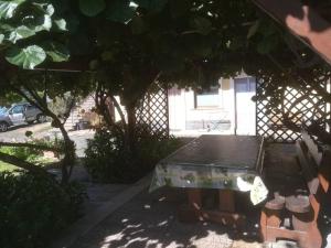 a picnic table in the shade of a house at Biologico Dell'Etna in Trecastagni