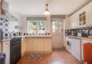 a kitchen with a sink and a dishwasher at Pineapple Cottage in Holt