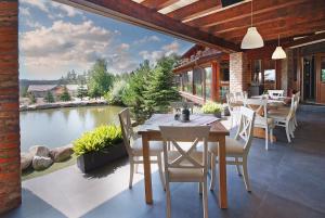 a patio with tables and chairs and a view of a lake at Complex Turistic Creanga Resort & Spa in Tîrgu Ocna