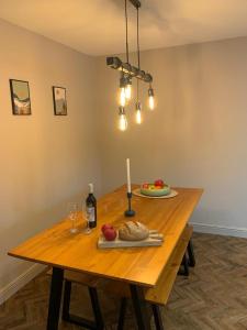 - une table en bois avec une bougie et une assiette de nourriture dans l'établissement Apple Tree at Elim Mews, à Bowness-on-Windermere