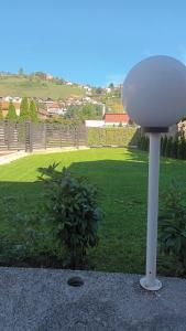 un poste blanco en un patio con un campo de hierba en Sve u jednom en Bijelo Polje
