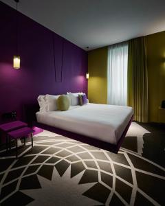 a bedroom with a large bed with purple walls at MyTALE Creative Academy Hotel in Rome
