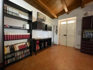 a living room with a large book shelf filled with books at Wonderful house in the heart of Sicily in Piazza Armerina