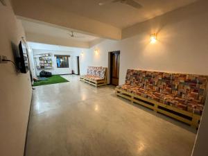 a living room with couches and chairs in a room at Eness Hostels Pondicherry in Puducherry