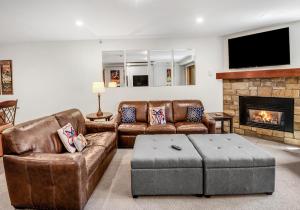 Elle comprend un salon doté d'un mobilier en cuir et d'une cheminée. dans l'établissement Lionsquare Lodge North #294 condo, à Vail