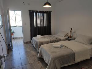 um quarto com duas camas e uma janela em LAVALLE 80 - CORRIENTES - A PASOS DE PLAYA Y COSTANERA em Corrientes