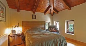 1 dormitorio con cama y techo de madera en Plethora Arachova Luxury Chalet, en Arachova