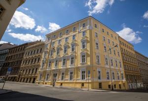 un edificio amarillo al lado de una calle en NaNa Flat, en Praga