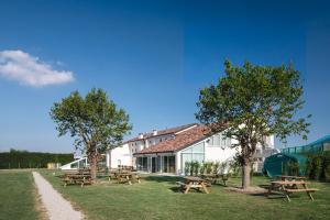 a group of picnic tables in front of a building at Nomad Hostel in Treviso