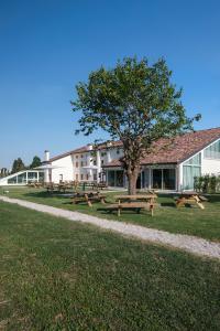 grupa stołów piknikowych przed budynkiem w obiekcie Nomad Hostel w mieście Treviso