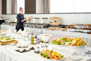 a buffet line with plates of food on a table at Hotel Tatra in Bratislava