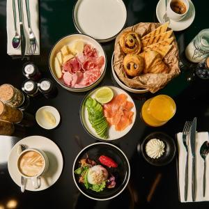 a table with several plates of food on it at MyTALE Creative Academy Hotel in Rome