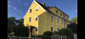 a yellow house with a gambrel roof at Fine Ferienwohnung Bayreuth in Bayreuth