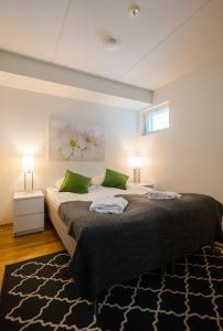 um quarto com uma cama grande e 2 almofadas verdes em Finlandia Hotel Aquarius em Uusikaupunki