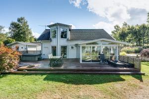 ein Haus mit einer Holzterrasse und einer Terrasse in der Unterkunft Luxury holiday home in Tallbacken with lake views over Bolmen in Ljungby
