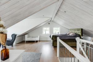 a attic bedroom with a bed and a staircase at Luxury holiday home in Tallbacken with lake views over Bolmen in Ljungby