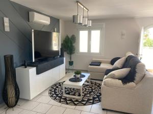 ein Wohnzimmer mit einem Sofa und einem TV in der Unterkunft Villa Greyjoy - AzulenaCalpe in Calpe