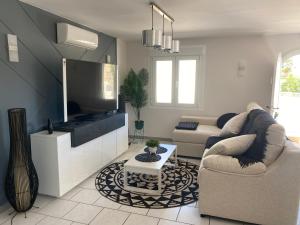 Una sala de estar con un sofá y un televisor. en Villa Greyjoy - AzulenaCalpe, en Calpe