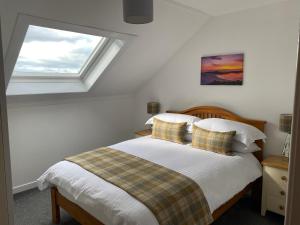 a bedroom with a bed with a window at Innisfree Self Catering Apartment, Banavie, Fort William in Fort William
