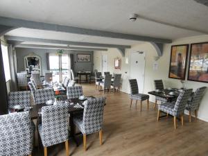 uma sala de jantar com mesas e cadeiras num quarto em The Riverside Hotel em Monmouth