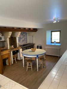 a kitchen with a table and chairs in a room at Moulin d'Ignières in Parcé-sur-Sarthe
