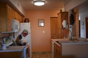 a kitchen with orange walls and a white refrigerator at Golf course condo in Moab in Moab