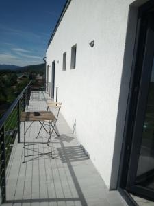 einen Balkon mit einem Tisch und Stühlen auf einem Gebäude in der Unterkunft Casa Prieteniei - camere - 3 km Piatra Neamț in Piatra Neamţ