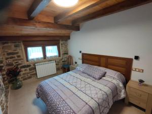 a bedroom with a bed and a stone wall at CASA PESCA VERA in Senegüé
