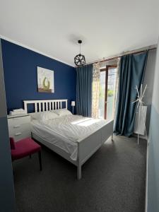 a bedroom with a bed and a red chair at airport comfy guest home in Warsaw