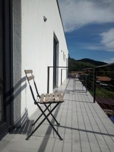 una silla sentada en el balcón de un edificio en Casa Prieteniei - camere - 3 km Piatra Neamț, en Piatra Neamţ