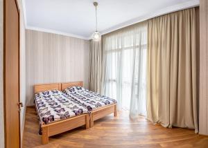 トビリシにあるHB apartments Vazha Pshavelaのベッドルーム1室(ベッド1台、大きな窓付)