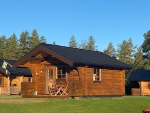 a log cabin with a black roof at Camping Fredrika-Braber in Fredrika