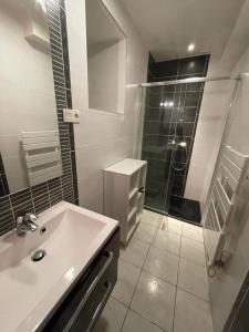 La salle de bains est pourvue d'un lavabo et d'une douche en verre. dans l'établissement Baie du mont saint michel - 6 personnes - Spa privatif, à Roz-sur-Couesnon