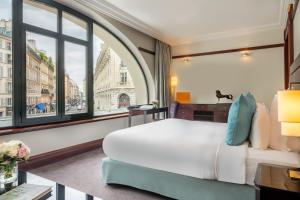 a hotel room with a bed and a window at Hôtel Pont Royal Paris in Paris