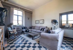 a living room with a couch and a table at La Ragotière in Froyennes