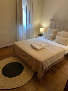 ein Schlafzimmer mit einem großen Bett mit Handtüchern darauf in der Unterkunft APARTAMENTOS TURÍSTICOS, PONCE DE LEÓN, Deluxe in Ronda