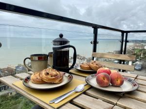 una mesa con dos platos de bollería y manzanas. en Seascape - 2 bedroom flat with panoramic sea views, en Hollington