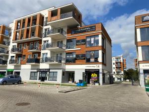 an apartment building with a parking lot in front of it at Apartament Mazovia Prestige in Płock