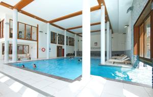 - une piscine dans un bâtiment avec des personnes dans l'établissement travelski home premium - Résidence Edenarc 5 stars, à Arc 1800