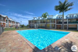 a swimming pool in front of a building at T3 Rustica - Duplex à Saint-Denis in Sainte-Clotilde