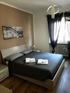 a bedroom with a large bed with two towels on it at Appartamento "Roby" in pieno centro a Cavalese in Cavalese