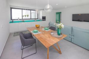 a kitchen and dining room with a wooden table and chairs at Cascasas The Green Apartment in Corralejo