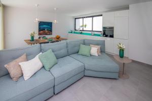 a living room with a blue couch with pillows at Cascasas The Green Apartment in Corralejo