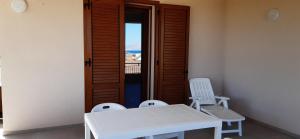 una mesa y dos sillas frente a una puerta en Casa vacanza Luisa, en Alcamo Marina